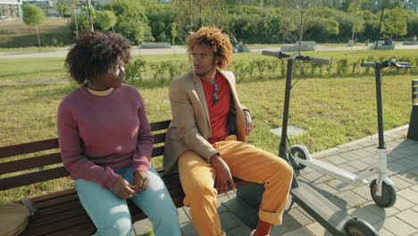 Black-Man-and-Woman-Sitting-in-Park-and-Chatting